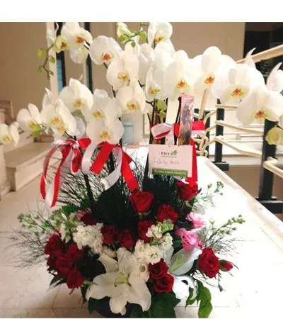 Großes Arrangement aus weißen Orchideen, roten Rosen und Lilien