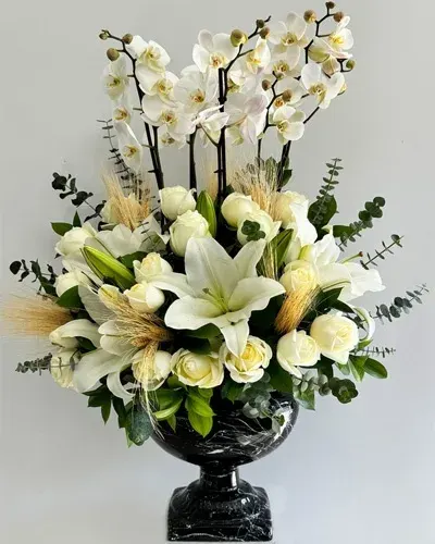 Weiße Orchideen, Lilien und Rosen in Marmor-Pokalvase
